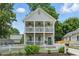 Charming two-story home featuring a double balcony, fresh landscaping, and a classic white picket fence at 683 Terry Se St, Atlanta, GA 30315