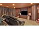 Finished basement featuring carpet, leather seating, and large TV with paneled walls and ceiling at 525 Wallis Farm Ln, Marietta, GA 30064