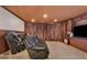 Finished basement with carpet, leather seating, and large TV, paneled walls and ceiling at 525 Wallis Farm Ln, Marietta, GA 30064