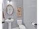 Clean, half bathroom featuring a pedestal sink, toilet, and oval mirror with neutral paint at 525 Wallis Farm Ln, Marietta, GA 30064