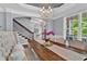 Dining room with decorative rug, chandelier, and long wooden table, stairs visible in background at 525 Wallis Farm Ln, Marietta, GA 30064