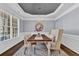 Elegant dining room featuring a tray ceiling, modern chandelier, and decorative rug with a large window at 525 Wallis Farm Ln, Marietta, GA 30064