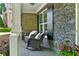 Cozy front porch with stone accents, rocking chairs, and potted plants, offering a relaxing outdoor space at 525 Wallis Farm Ln, Marietta, GA 30064