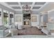 Bright living room with stone fireplace, coffered ceilings, large windows, and comfortable seating offers a cozy gathering space at 525 Wallis Farm Ln, Marietta, GA 30064