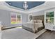 Luxurious main bedroom boasts a tray ceiling with a chandelier, plush carpet, and serene natural light at 525 Wallis Farm Ln, Marietta, GA 30064