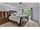 Comfortable primary bedroom with large window, patterned bedding, dresser, and neutral colors at 525 Wallis Farm Ln, Marietta, GA 30064