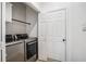 Modern laundry room with stainless steel appliances and stylish wallpaper at 6788 Oakhurst Court Ct, Douglasville, GA 30134
