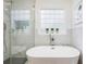 Elegant bathroom with modern soaking tub, glass shower, and accent tile at 6788 Oakhurst Court Ct, Douglasville, GA 30134