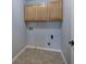 A compact laundry room with neutral-toned tiled flooring and light wood cabinets at 11 Trotters Ne Walk, Cartersville, GA 30121