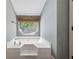 Bright bathroom area featuring a large soaking tub and a window with a shade at 185 Hickory View Dr, Lawrenceville, GA 30046