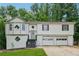Split level home with attached garage, interesting window design, and front yard grass at 185 Hickory View Dr, Lawrenceville, GA 30046