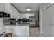 Open kitchen featuring white cabinets, granite countertops, tiled floor, and stainless appliances at 200 Mona Ct, Lawrenceville, GA 30044
