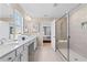 Bright bathroom featuring a glass enclosed shower, double sink vanity, and ensuite access to main bedroom at 2545 Dixon Pl, Lawrenceville, GA 30045