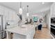 Kitchen with stone countertops on a large island connecting to an open-concept living area at 2545 Dixon Pl, Lawrenceville, GA 30045