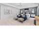 Spacious main bedroom featuring tray ceilings, modern lighting, two upholstered arm chairs, and ensuite bathroom access at 2545 Dixon Pl, Lawrenceville, GA 30045