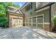 Attached three-car garage showcasing paneled doors, stone accents and a spacious driveway at 1323 Frey Lake Ct, Kennesaw, GA 30144