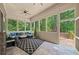Spacious screened porch with slate flooring, a comfortable lounge area, and backyard views at 1323 Frey Lake Ct, Kennesaw, GA 30144
