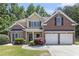 Charming two-story brick and siding home with a manicured front yard and two-car garage at 1611 Hillside Bend Xing, Lawrenceville, GA 30043