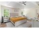 Relaxing primary bedroom featuring a king-sized bed, ceiling fan, and natural light at 1611 Hillside Bend Xing, Lawrenceville, GA 30043