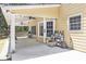 Covered patio provides a functional outdoor space with yellow siding and storage cart at 1611 Hillside Bend Xing, Lawrenceville, GA 30043