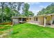 Spacious backyard with mature trees, lush green grass, and patio area at 3332 Saint John Dr, East Point, GA 30344