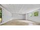 Unfinished basement with concrete floor, drop ceiling, and large window at 3332 Saint John Dr, East Point, GA 30344