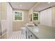 Stylish bathroom with patterned wallpaper, black-and-white tile floor, and a large mirror at 3332 Saint John Dr, East Point, GA 30344