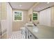 Bright bathroom with black and white tile flooring, yellow patterned wallpaper, large mirror and vanity at 3332 Saint John Dr, East Point, GA 30344