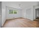 A bright bedroom featuring wood floors, a ceiling fan and a large window overlooking mature trees at 3332 Saint John Dr, East Point, GA 30344