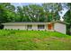 Charming single-story white brick home with a well-manicured green lawn and an orange front door at 3332 Saint John Dr, East Point, GA 30344