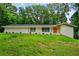 Charming brick ranch-style home featuring a bright orange front door and a lush green lawn at 3332 Saint John Dr, East Point, GA 30344