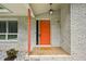Close-up of the home's front entrance showing the painted orange door and stone walkway at 3332 Saint John Dr, East Point, GA 30344