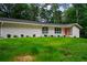 Charming brick home with a well-manicured front yard, freshly cut lawn, and an orange front door at 3332 Saint John Dr, East Point, GA 30344