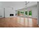 Large living room with a painted brick fireplace and large windows overlooking the wooded yard at 3332 Saint John Dr, East Point, GA 30344