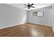 This bedroom includes wood-look flooring, light-colored walls, a fan, and a bright window at 3429 Timbercreek Dr, Lawrenceville, GA 30044