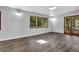 Spacious living room with wood-look flooring, a set of three windows, and a glass paneled door at 3429 Timbercreek Dr, Lawrenceville, GA 30044