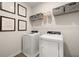 Well-lit laundry room featuring a modern washer and dryer, wire shelving, and framed architectural prints at 84 Ravencliff Dr # 84, Austell, GA 30168