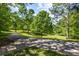Exterior shot of property with a paved driveway lined by green trees and grass, creating a park-like setting at 907 Edgewood Ave Ne, Atlanta, GA 30307