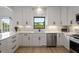 Bright kitchen with white cabinets, stainless steel appliances, modern backsplash and hardwood flooring at 907 Edgewood Ave Ne, Atlanta, GA 30307