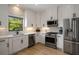 Bright kitchen featuring white cabinets, stainless steel appliances, and marble-look backsplash at 907 Edgewood Ave Ne, Atlanta, GA 30307