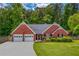 Charming, single-story brick home featuring a two-car garage, well-manicured lawn, and lush landscaping at 175 Prince Ct, Hiram, GA 30141