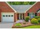 Inviting front entrance, showcases a brick facade, manicured bushes, and flower bed at 175 Prince Ct, Hiram, GA 30141