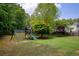 Large backyard featuring a play set with swings and a slide in a lush, green yard with privacy fence at 175 Prince Ct, Hiram, GA 30141