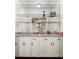 Stylish bar with white cabinets, granite countertops, and glass shelving at 410 Glenmont Ct, Atlanta, GA 30350