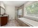 Luxurious bathroom featuring a soaking tub, a separate glass enclosed shower, and a vanity at 410 Glenmont Ct, Atlanta, GA 30350