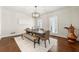 Elegant dining room with a long table, decorative lighting, hardwood floors, and ample natural light at 410 Glenmont Ct, Atlanta, GA 30350