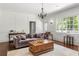 Inviting living room featuring hardwood floors, neutral decor, a fireplace, and large windows at 410 Glenmont Ct, Atlanta, GA 30350