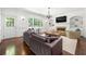 Cozy living room with a fireplace, large windows, hardwood floors, and a comfortable gray sofa at 410 Glenmont Ct, Atlanta, GA 30350