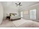 Spacious main bedroom with tray ceilings, neutral carpet, ample lighting, and large bed at 410 Glenmont Ct, Atlanta, GA 30350