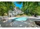 The backyard featuring a swimming pool, lounge chairs, privacy fence, and lush landscaping at 410 Glenmont Ct, Atlanta, GA 30350